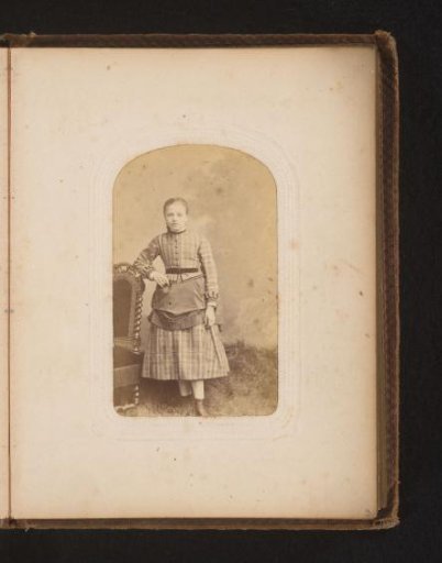 Portrait of a girl standing by a chair