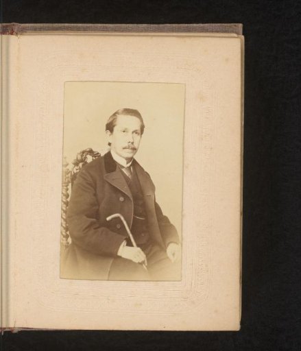 Portrait of a seated man with walking stick in hand