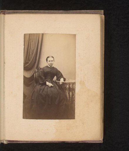 Portrait of a woman, seated at a table