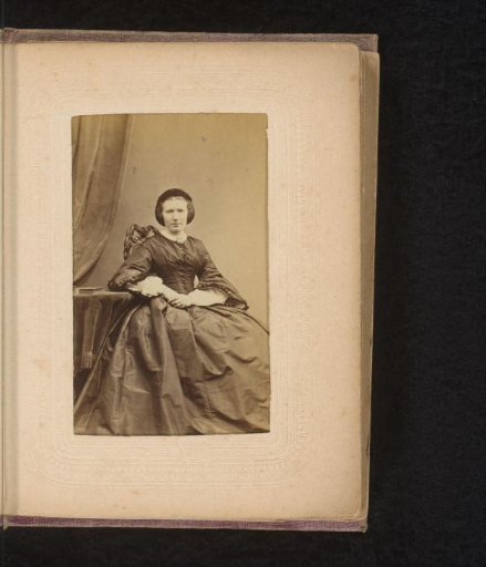 Portrait of a woman, seated at a table