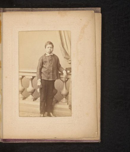 Portrait of a boy, standing by a balustrade