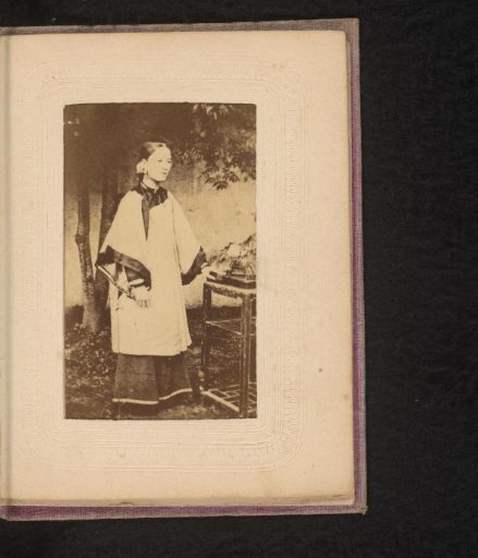 Portrait of a standing Chinese girl in a studio with Oriental decor