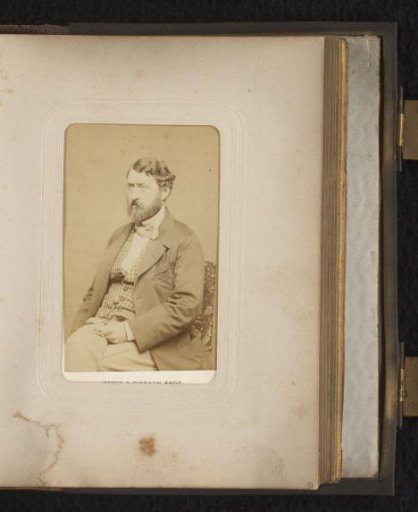 Portrait of a seated man with a moustache and beard