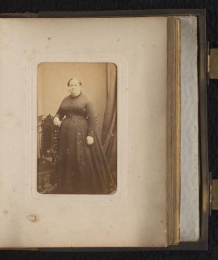 Portrait of a woman standing by a chair