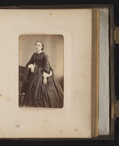 Portrait of a woman standing by a piece of furniture