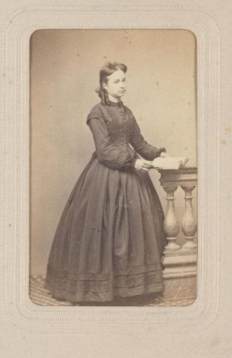 Portrait of a woman with a book in her hands, standing by a balustrade