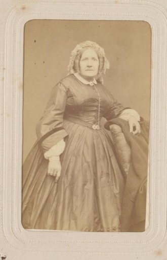 Portrait of a Woman with a Cap, Standing by a Chair