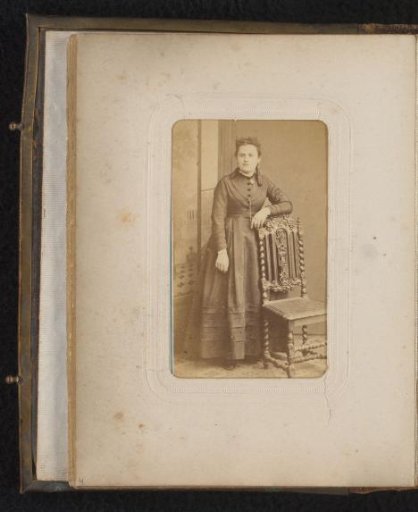 Portrait of a woman, standing by a chair