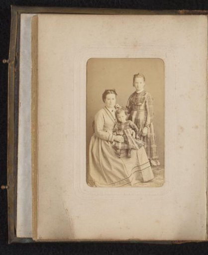 Portrait of a seated woman with a toddler on her lap and a standing girl