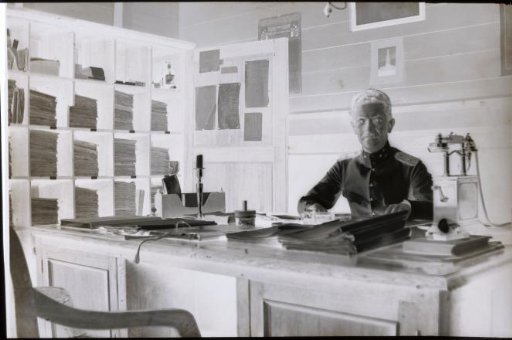 Man in uniform seated behind his desk in Padang