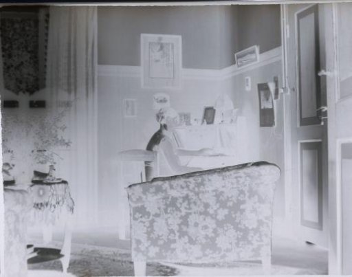 Woman designated as Suzi seated on a chair in a room
