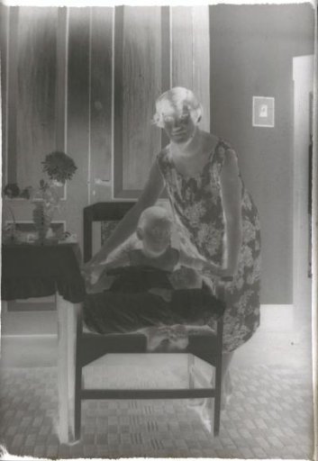 Woman standing beside a young child in a chair