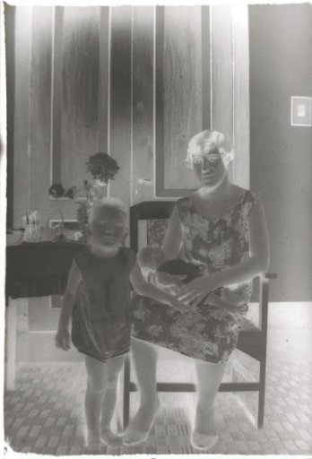 Young child standing beside a woman in a chair
