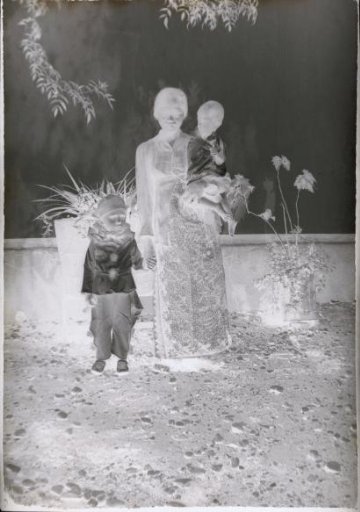 Indonesian child nurse (then called 'baboe') with two children (Pitteke and Fritsje), one (Pitteke) dressed as a Pierrot