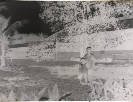 Two children, one designated as 'Fritsje', in a garden with a toy bucket