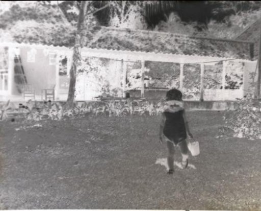 Child designated as 'Fritsje' in a garden with a toy bucket