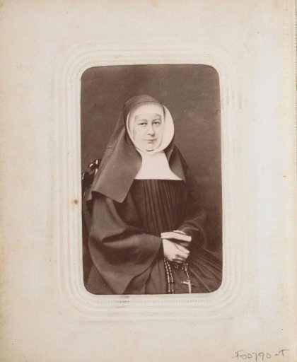 Portrait of a seated nun with a veil and a rosary in her hand