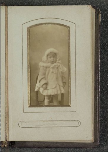 Portrait of a young girl in a short jacket with a cap