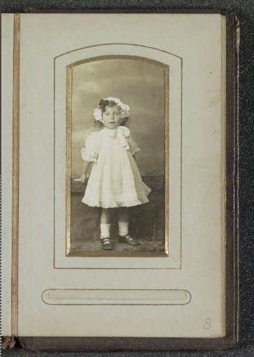 Portrait of a young girl in a dress with a cap