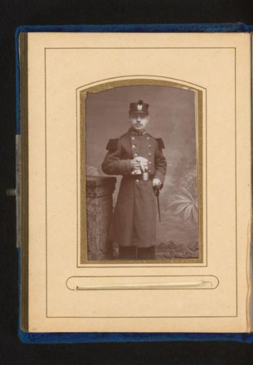 Portrait of a young man in military uniform holding gloves