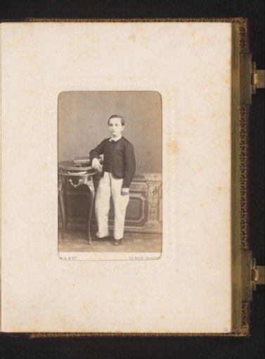 Portrait of a Boy Standing by a Table with a Book
