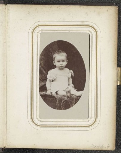 Portrait of a seated toddler in a white dress