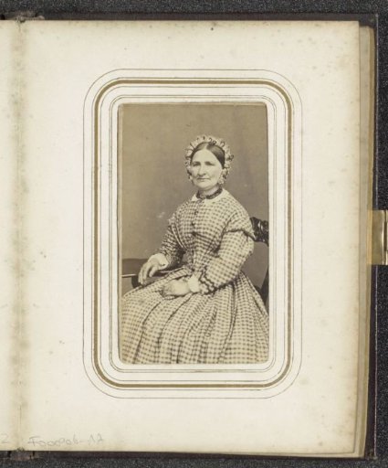 Portrait of a seated woman with a cap in a checkered dress