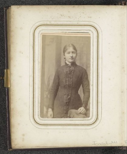Portrait of a standing young woman with a necklace and a bracelet