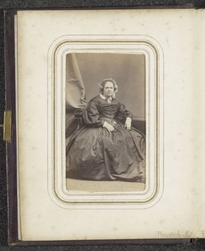 Portrait of a seated woman in a dress with a cap