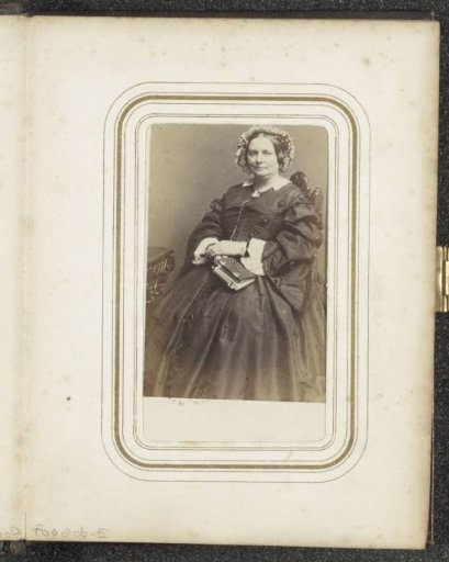 Portrait of a seated woman with a cap and (possibly) a photo album in her hand