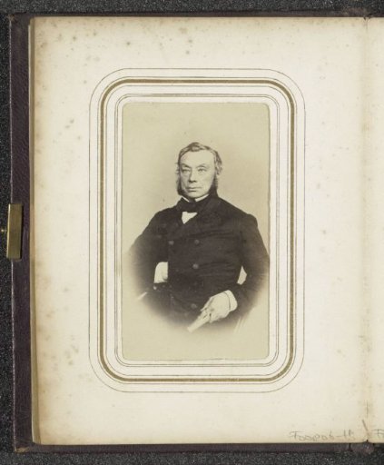 Portrait of a man with sideburns and a hand tucked into his coat
