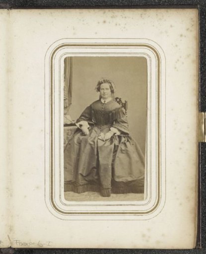 Portrait of a seated woman with a cap and (possibly) a photo album in her hand