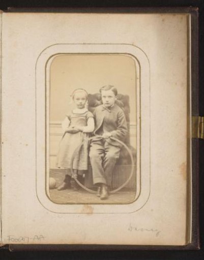 Portrait of a sitting boy with a hoop in his hand and a standing girl