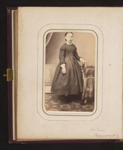 Portrait of a girl with a book in her hand, standing by a table