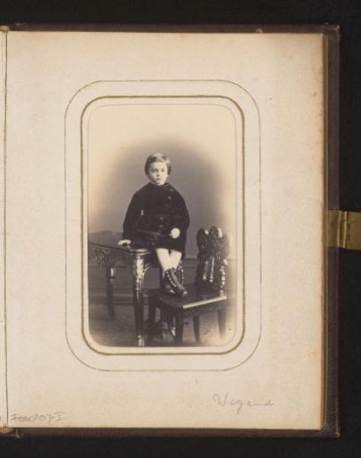 Portrait of a girl, sitting on a table with her feet on a chair