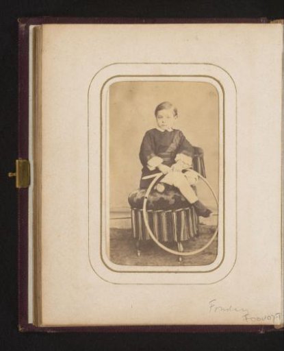 Portrait of a boy with a hoop in his hand, sitting on a chair