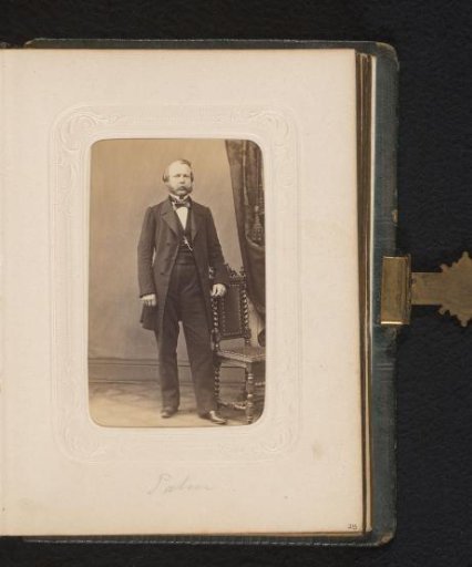 Portrait of a standing man by a chair, identified as A.V. Uddman