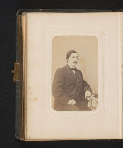 Portrait of a seated man with spectacles