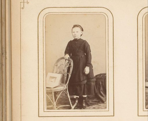Portrait of a Girl, Standing by a Chair with an Open Album