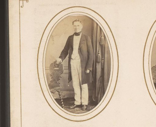 Portrait of a man standing by a chair