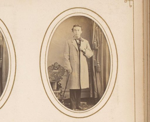 Portrait of a man with a walking stick in his hand, standing by a chair with a tall hat