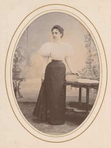 Portrait of a Woman Standing by a Table with a Book in a Setting