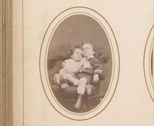 Portrait of a boy and a girl sitting against each other on a chair