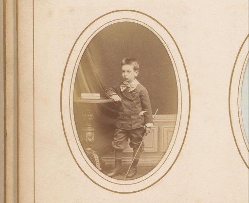 Portrait of a Boy with a Stick in His Hand, Standing by a Table with a Book