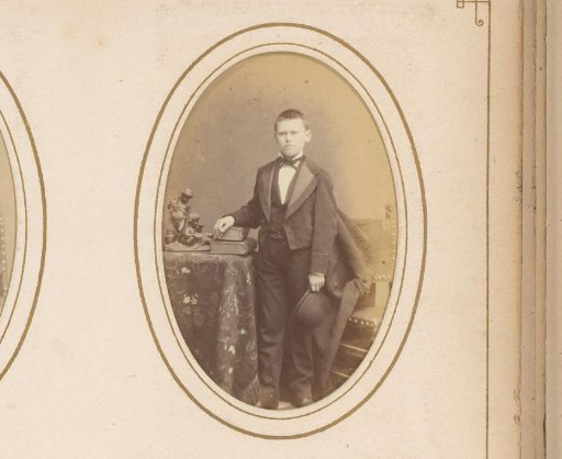 Portrait of a Boy with a Hat in His Hand, Standing Between a Table with Books and a Chair