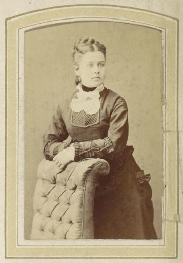 Portrait of a Woman in a Dress Leaning on an Armchair
