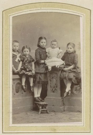 Portrait of five children by a wall