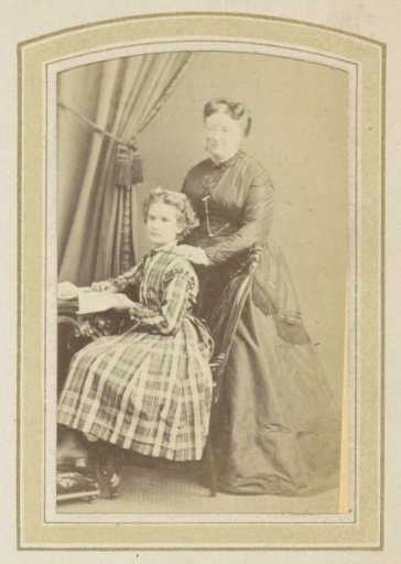 Portrait of a Girl in a Scottish Plaid Dress and a Woman in a Dress at a Table with Books