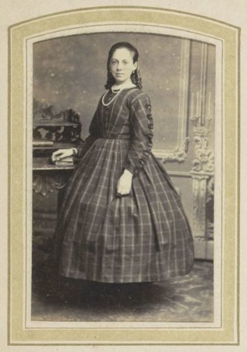 Portrait of a Girl in a Plaid Dress at a Table with Books