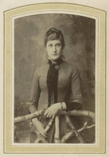 Portrait of a Woman in a Dress by a Fence